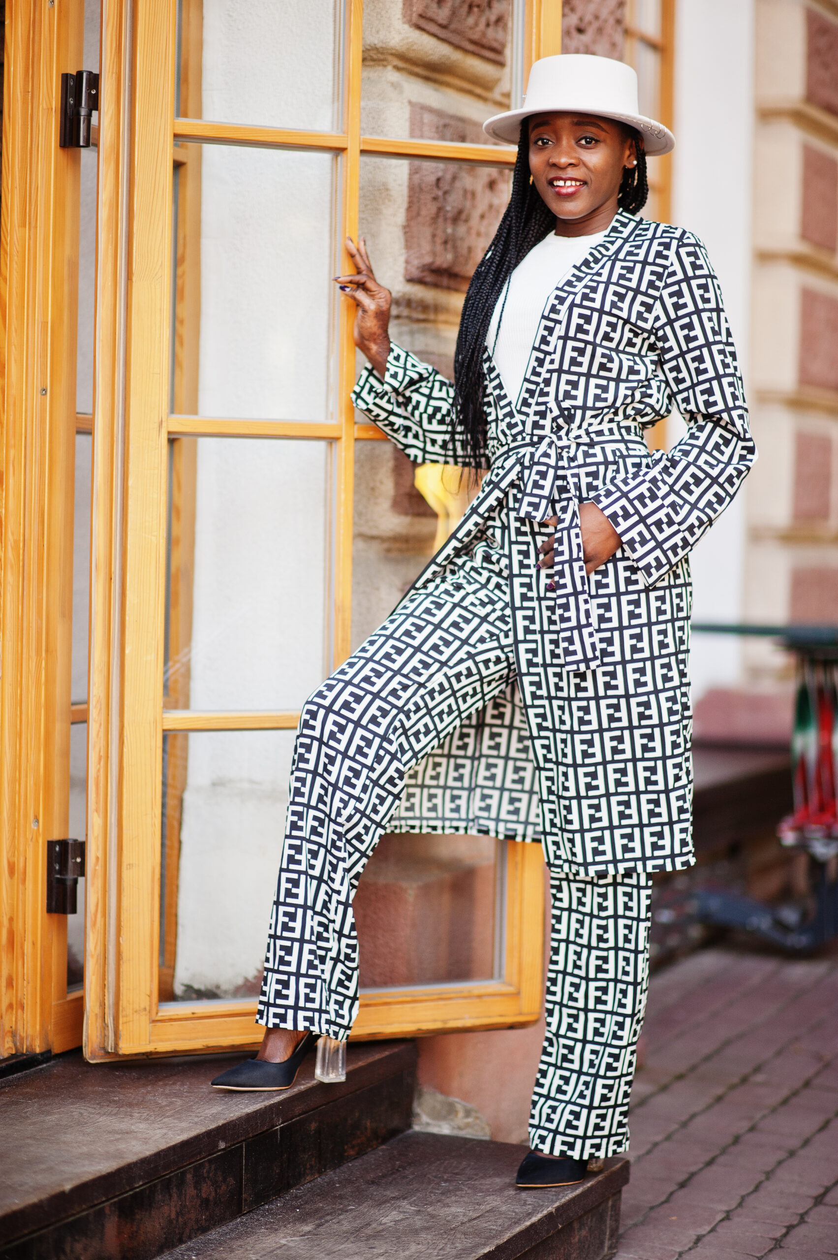 Beautiful african american woman natural makeup wear fashion clothes casual black and white dress code office style total blouse and pants suit and hat.